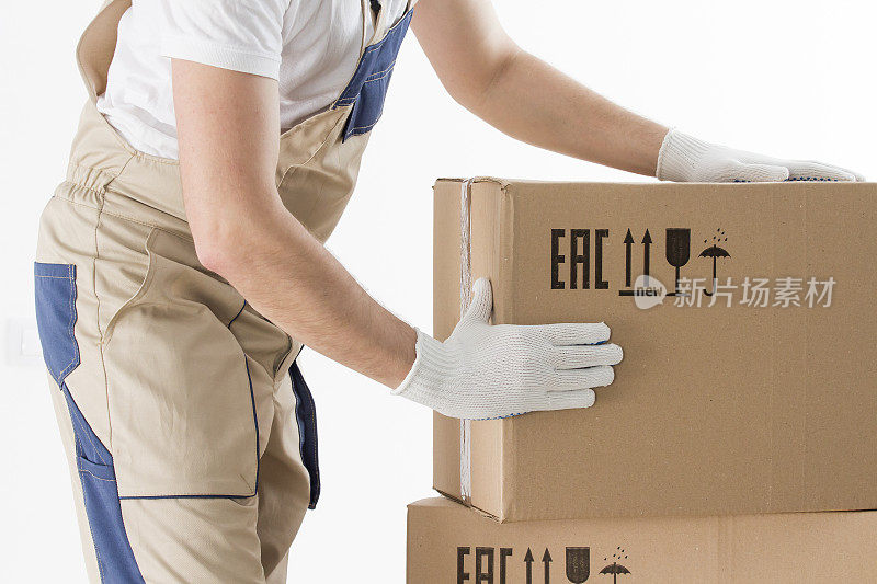 搬迁服务的概念。搬运工穿着制服的手拿着纸板箱。装载机将纸板箱隔离在白色背景上。搬运纸箱的工人。送货员