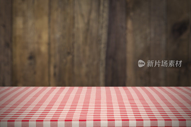 背景:红色和白色格子桌布与深色的垂直桌子背景