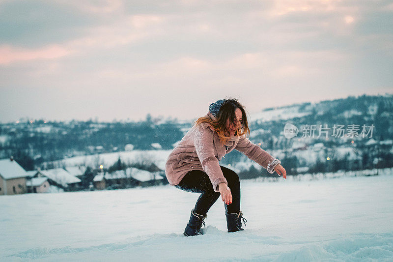 年轻女子在雪地上玩