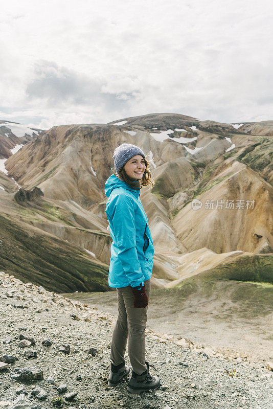 在冰岛的Landmannalaugar，一名妇女在彩色山脉附近徒步旅行