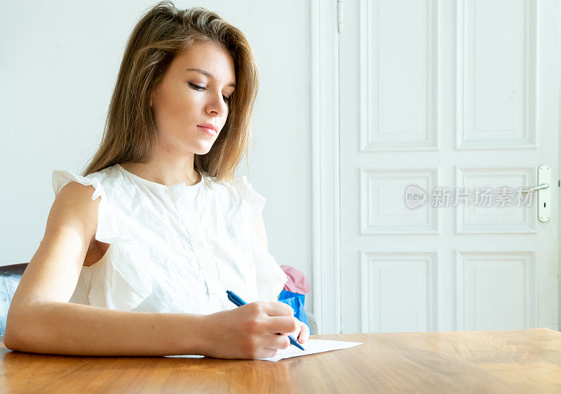 年轻女子在纸上写字