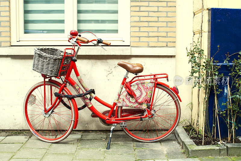 传统的红色荷兰自行车停在阿姆斯特丹的墙上