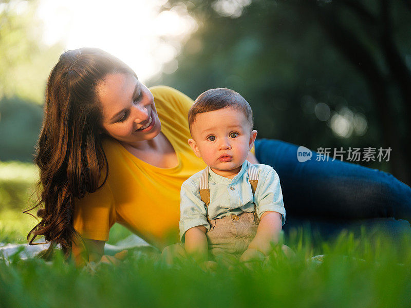 美丽的墨西哥母亲躺在男婴身后