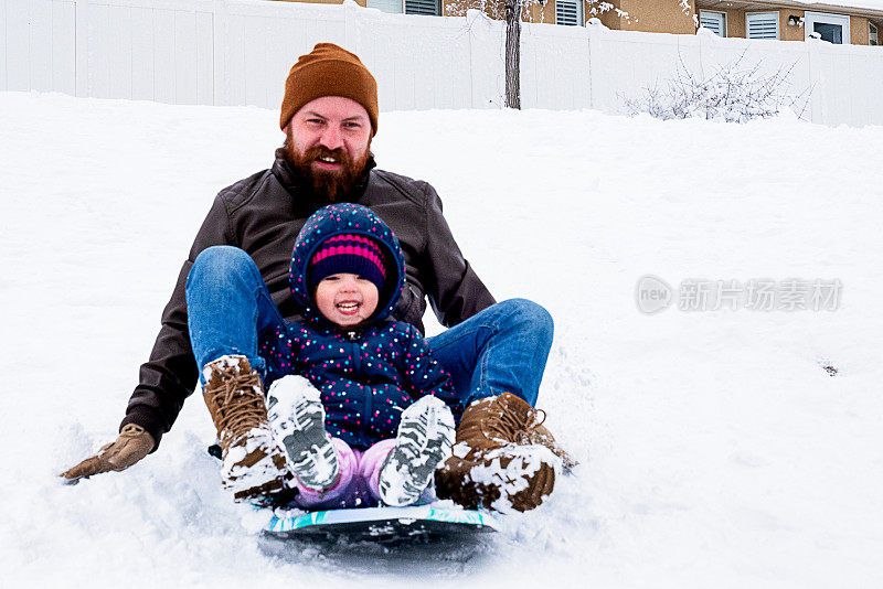 年轻人和小女孩在雪中滑雪