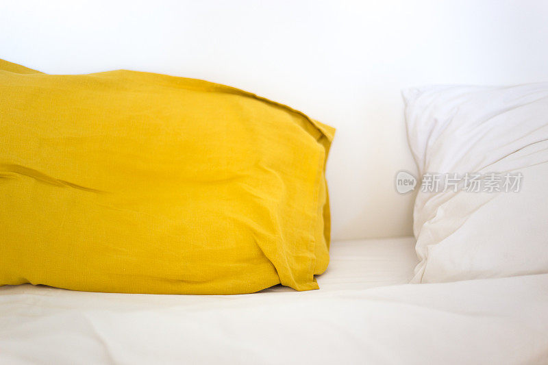 法国南部床与黄色和白色亚麻枕头，特写