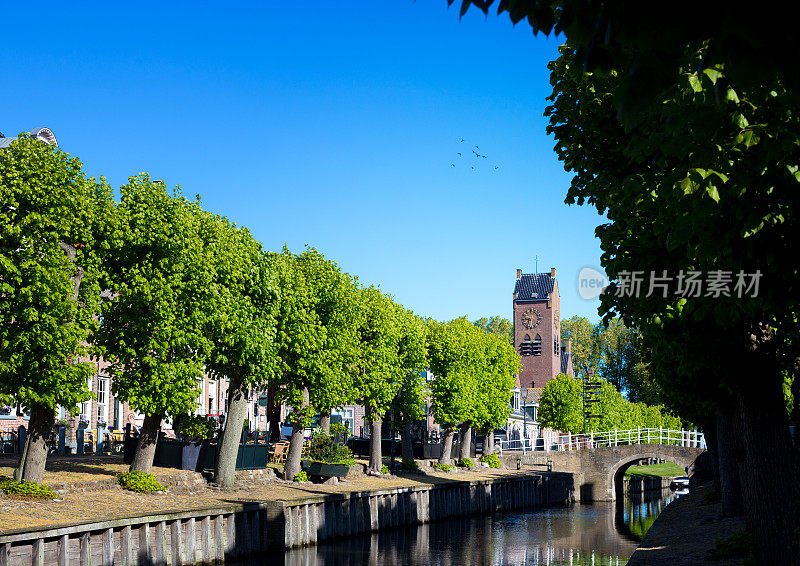 斯洛腾，弗里斯兰，荷兰:绿树成荫的运河，中世纪钟楼
