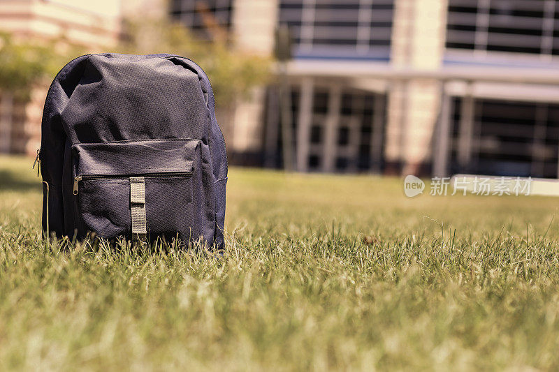 回到学校。蓝色的背包在学校大楼前的草地上。