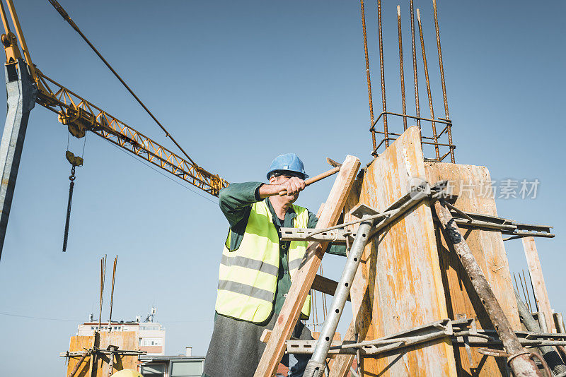 建筑工人正在建筑工地上和铁锤一起工作