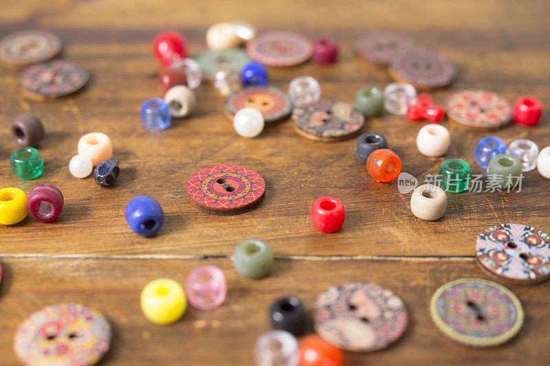 木质工艺桌上的彩色纽扣和珠子。伟大的背景图像。爱好。