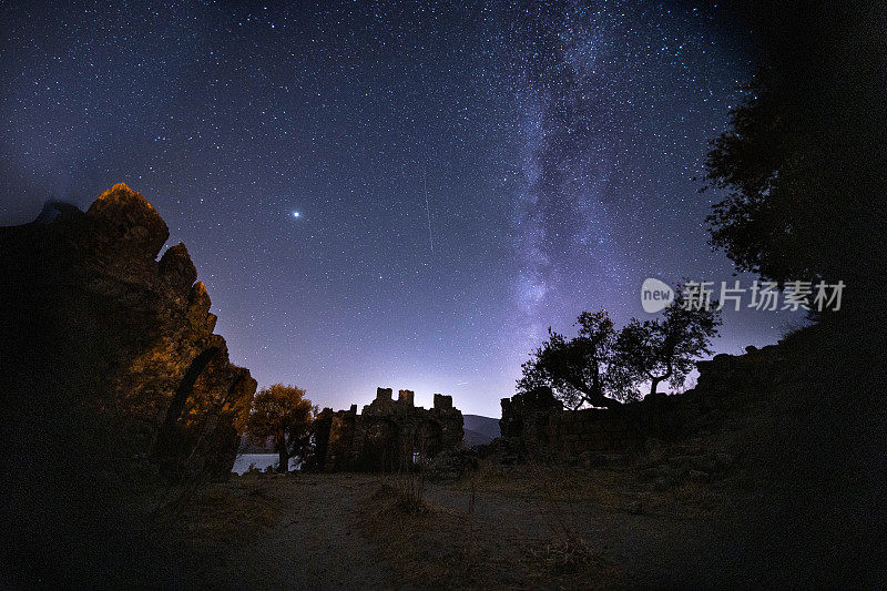 城堡的夜景。在前景中有一座山顶的银河系的星星的视图。夜空自然夏景。英仙座流星雨观测