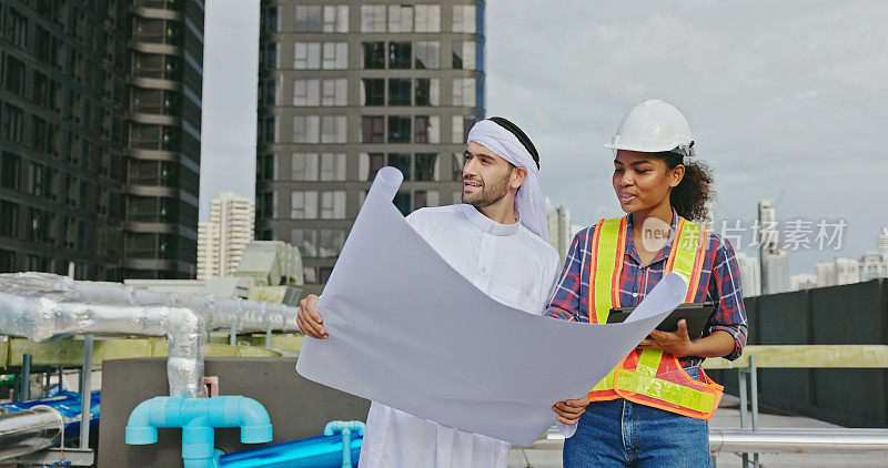 阿拉伯男性工程师与非洲裔美国女性承包商协商，检查和维护建筑的空气、水和电力管道系统。蓝领工人
