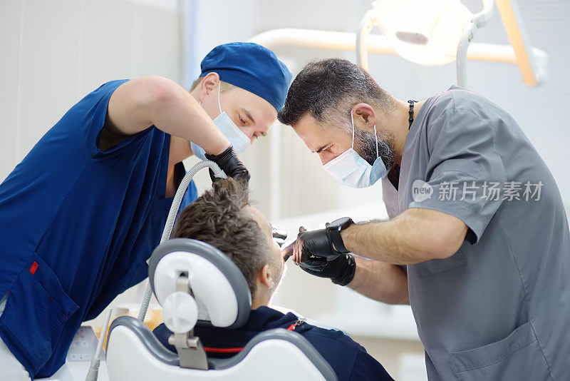 正在做牙科手术的外科医生在手术室麻醉病人。在诊所内安装植牙装置。