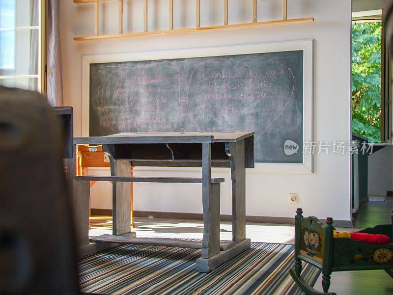 教室里有一张课桌，一块石板黑板，用粉笔写字