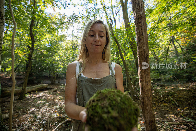 在她的手中握着森林里的绿色世界的女人