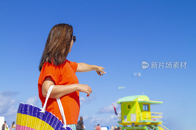 一名年轻的拉丁女子在世界著名的迈阿密海滩享受一日游，美国佛罗里达州南海滩，美国，阳光照亮在一个蓝色阳光灿烂的夏日中午。