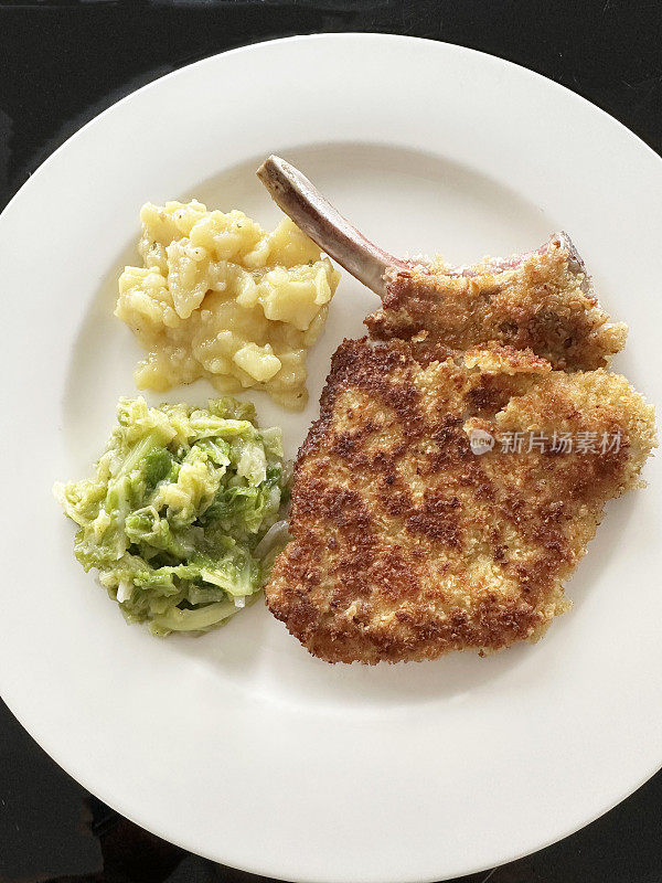 裹面包的小牛肉片配土豆沙拉和卷心菜