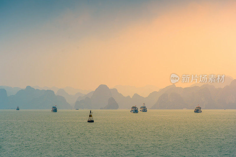 越南广宁省下龙湾景观;有很多石灰岩小岛和游轮;在一个蓝天的夏日
