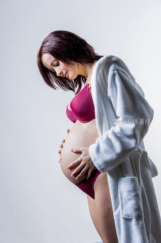 怀孕的年轻女子摸她的肚子