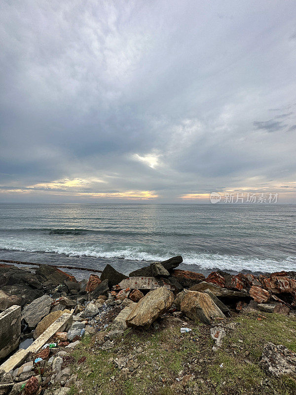 斯里兰卡海岸线上岩石自然海防的特写图像，海岸侵蚀抛石岩石装甲墙，海岸管理，岩石堆，海滩岩石装甲，海浪，科伦坡，斯里兰卡