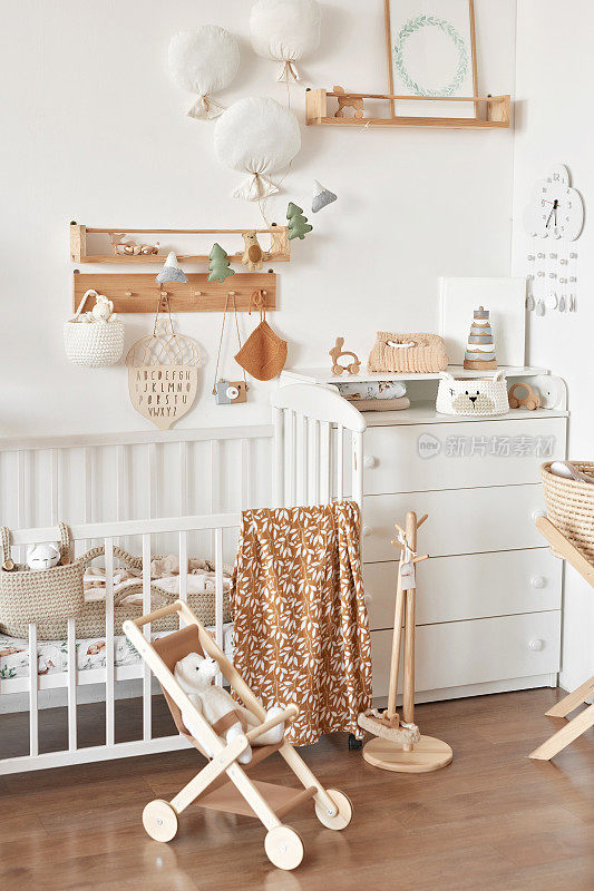 儿童益智木制玩具。育婴室装饰。斯堪的纳维亚风格的游戏室。木推车。婴儿床