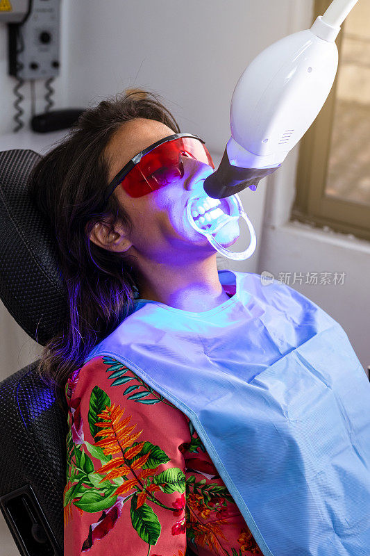 牙齿改造:一位女士正在接受专业激光牙齿美白