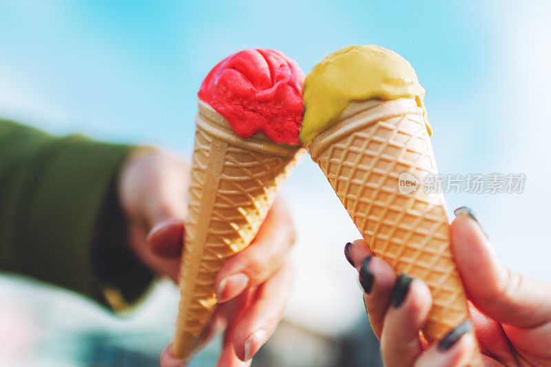 两个女人的手拿着冰淇淋