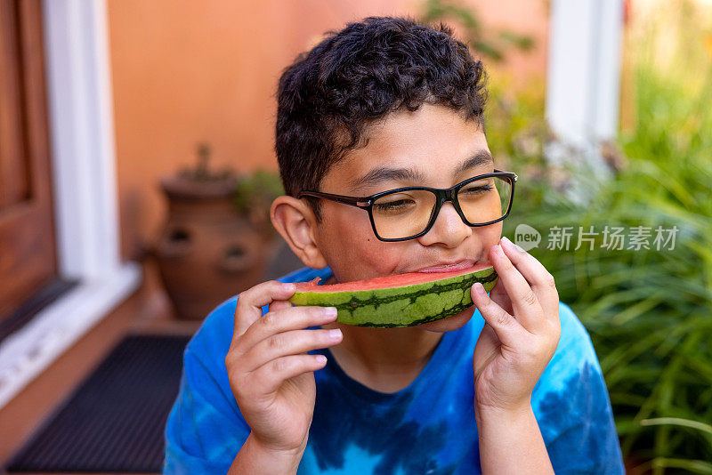 多种族男孩在门廊上吃西瓜