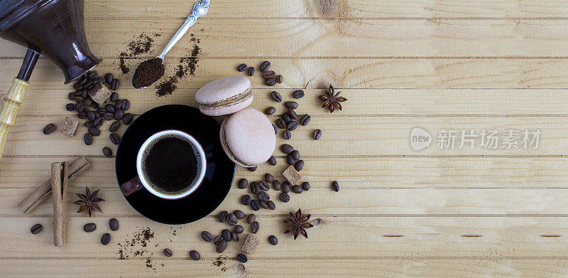 棕色杯子里的黑咖啡、马卡龙、咖啡豆和在木制背景上煮咖啡的土耳其人。副本的空间。前视图。