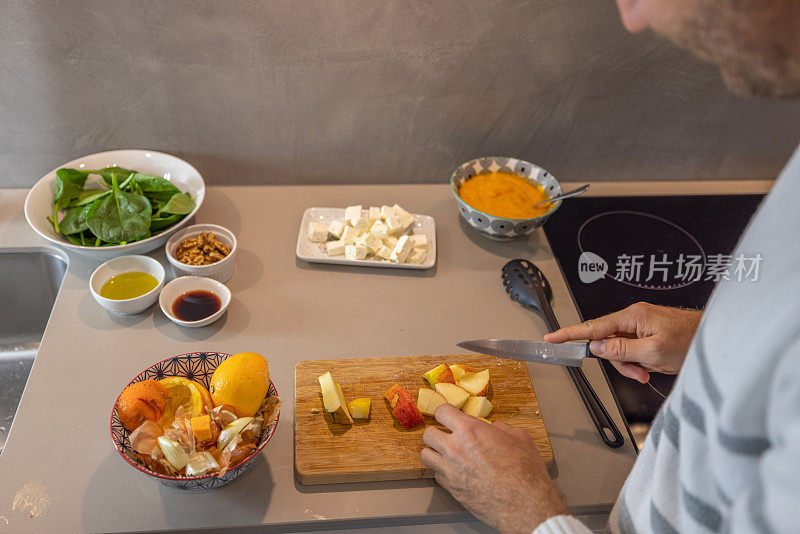 男子在自家厨房做饭，减少了家里的食物浪费