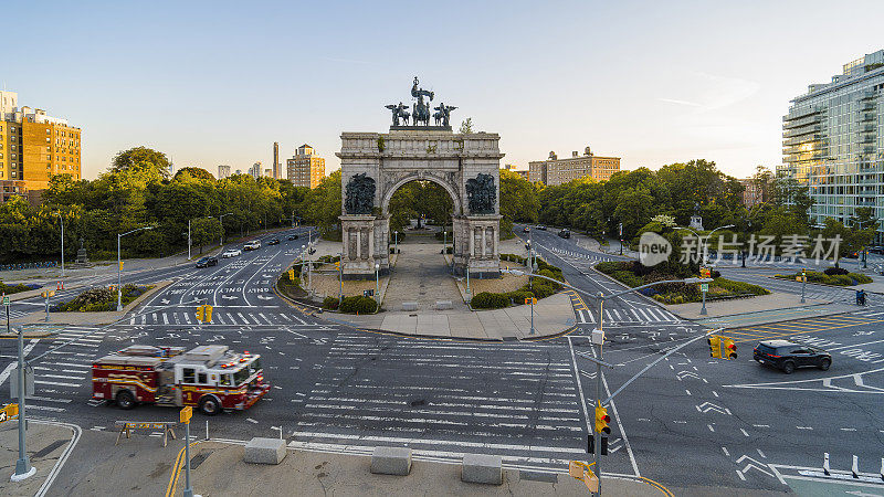 春天的清晨，一辆消防车和一辆救护车正经过纽约布鲁克林的陆军广场。
