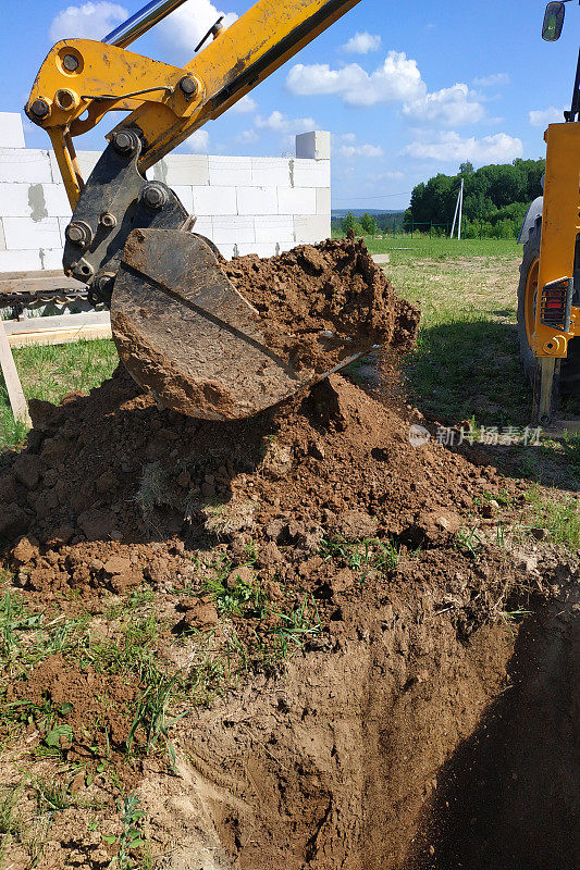挖掘机在工地上挖掘沟渠，近距离工作的过程。