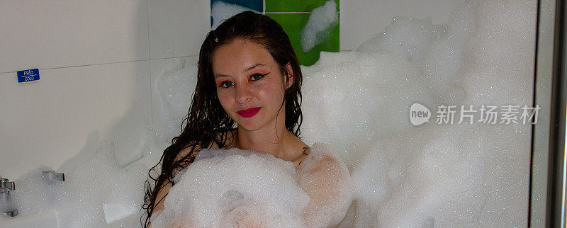 泡在泡沫浴缸里的年轻女子