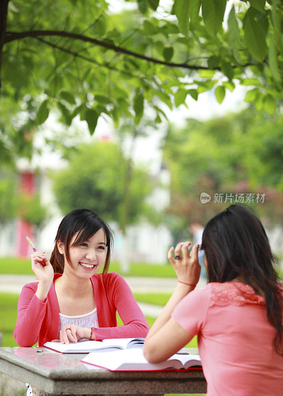 两个女大学生在校园里一起学习