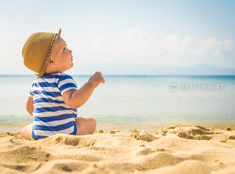 小男孩坐在沙滩上