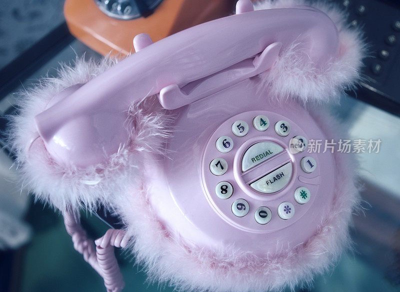复古的粉红色桌上电话与毛绒