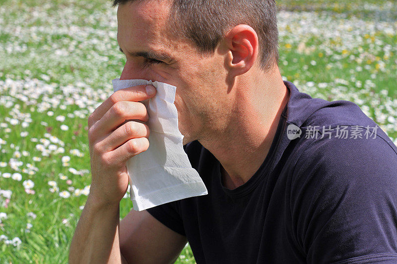 花粉过敏,春天。男人在纸巾里打喷嚏