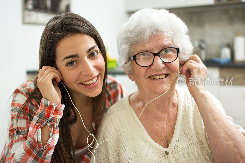 孙女和奶奶在家里听音乐。