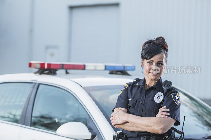 站在巡逻车旁边的女警官