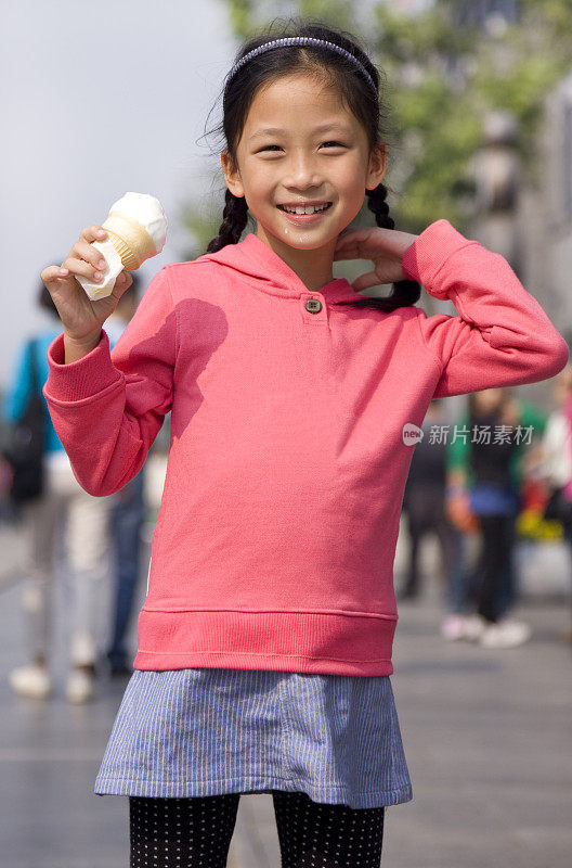 小女孩在户外吃冰淇淋蛋卷