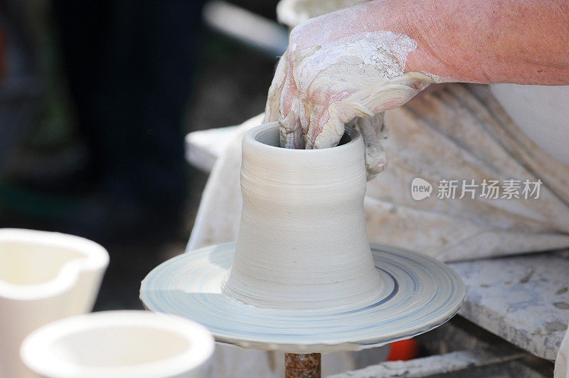 陶工手在陶工轮上转动烧杯。