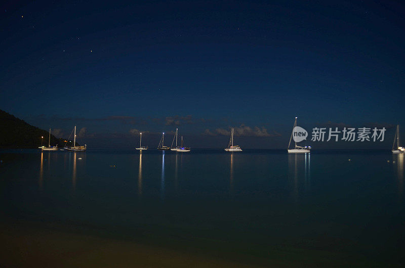 梦幻般的夜景，宁静的蓝色海洋和白色游艇