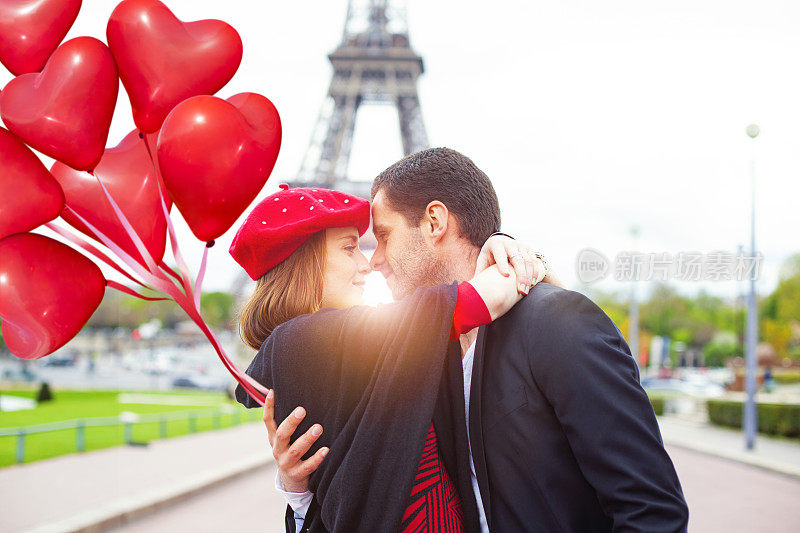 在巴黎的埃菲尔铁塔上，这对浪漫的情侣拥抱着彼此的鼻子