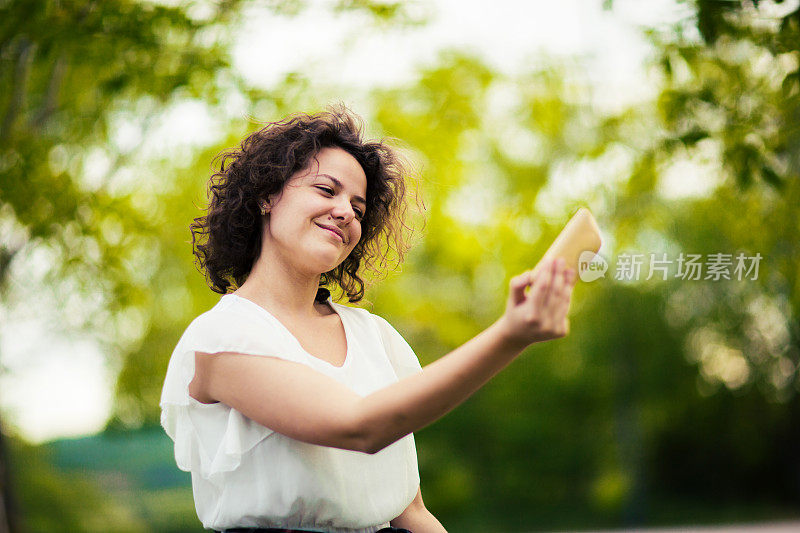 年轻女子在手机上拍了一张有趣的自拍