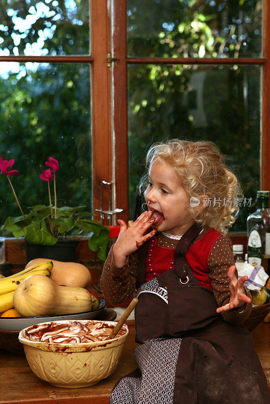 小女孩在吃蛋糕糖衣