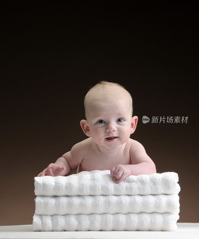 微笑的小男孩靠在XXL毛巾上