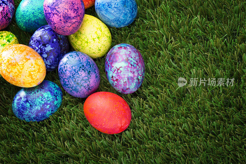 绿色草地上五颜六色的斑点复活节彩蛋