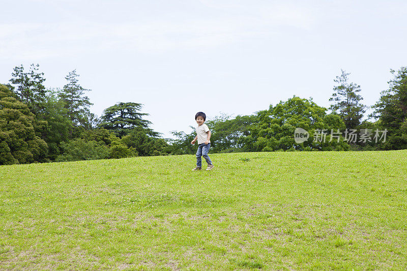 男孩在公园的草坪上玩耍