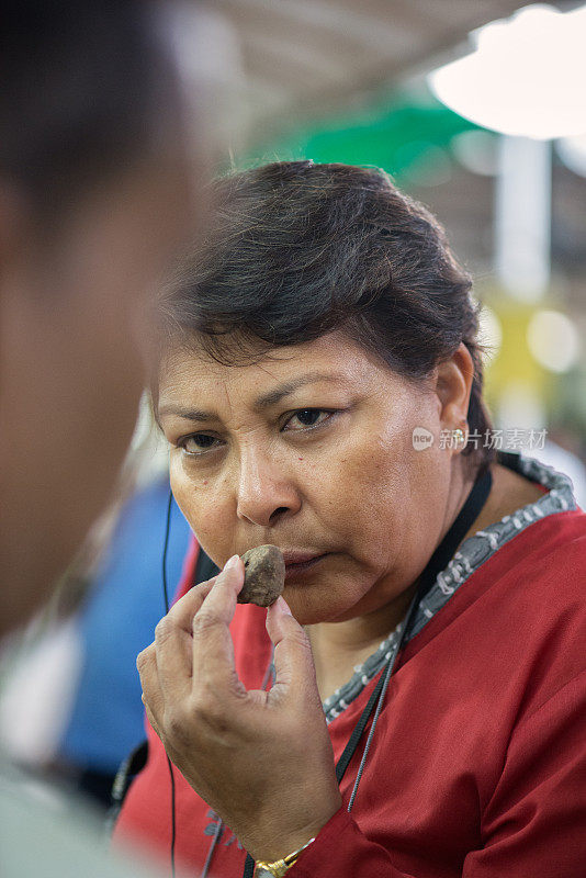 女顾客在市场上与卖主讨价还价松露价格