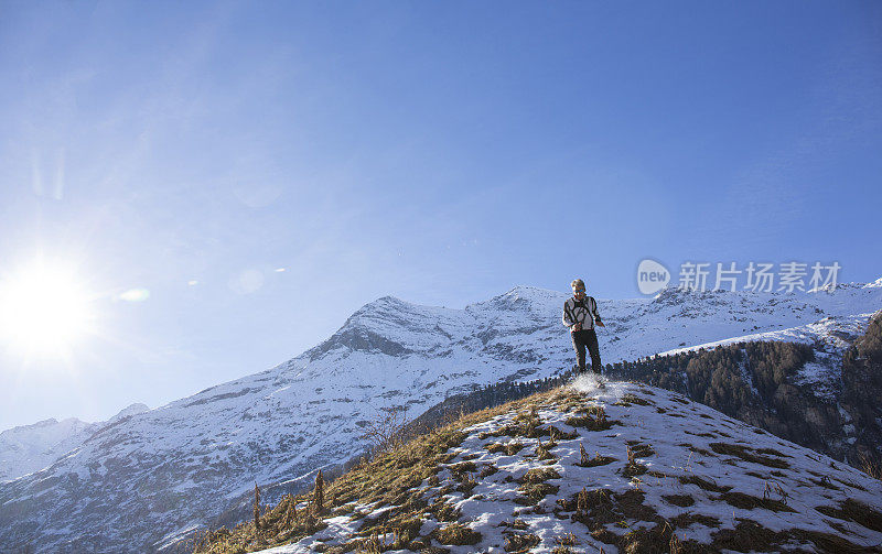 越野跑者蹦蹦跳跳地沿着积雪的山坡跑下去