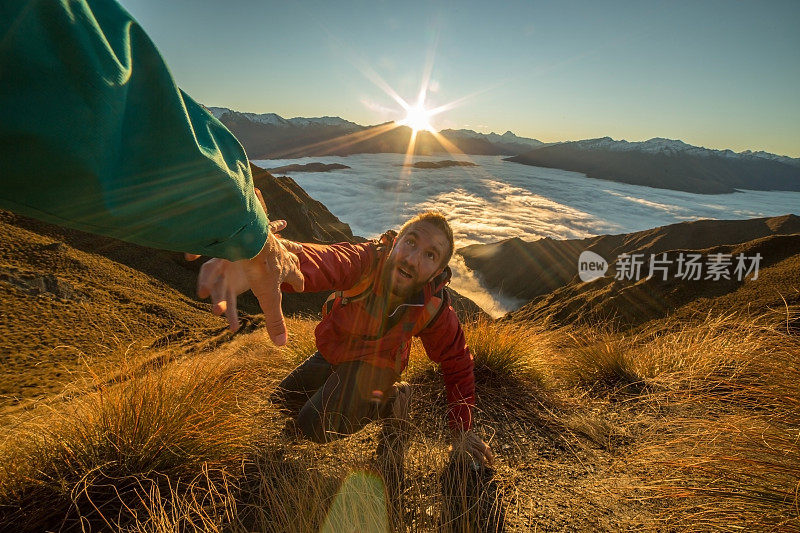 一个人在山顶伸出手寻求帮助